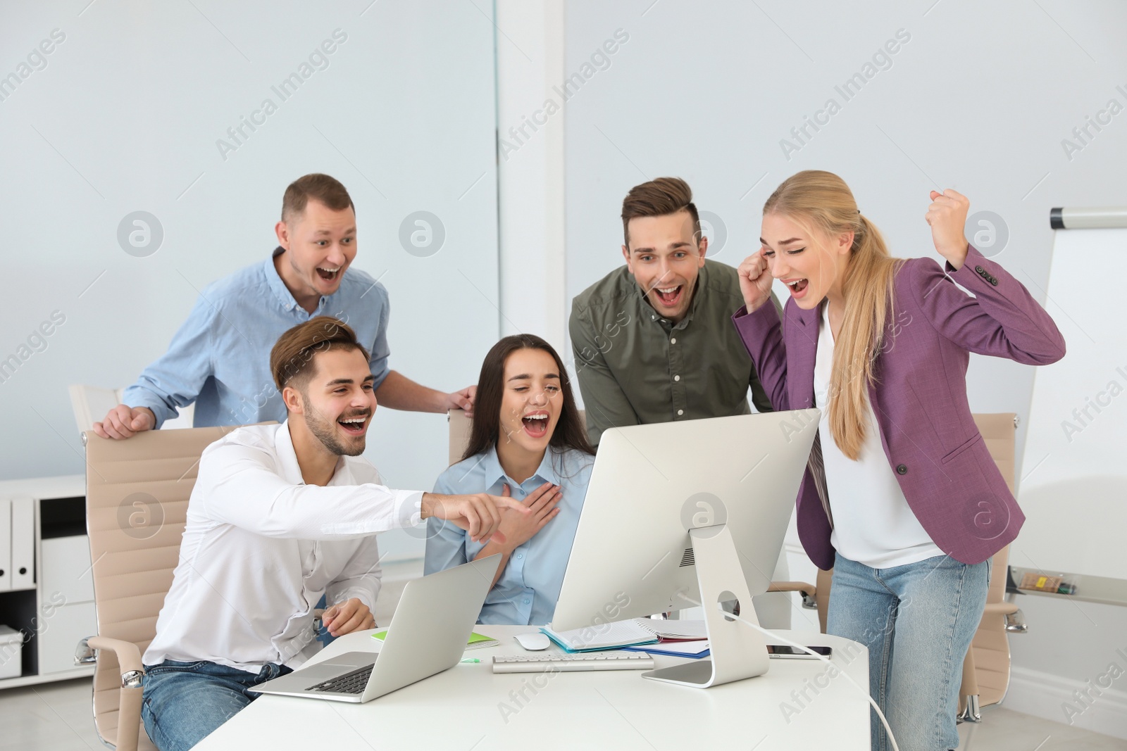 Photo of Group of office employees celebrating victory at workplace