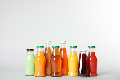 Bottles with different drinks on color background