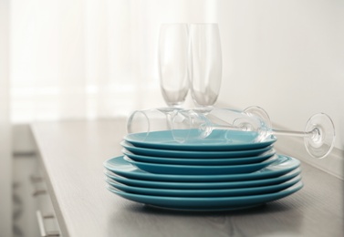 Photo of Set of clean dishware and champagne glasses on table indoors