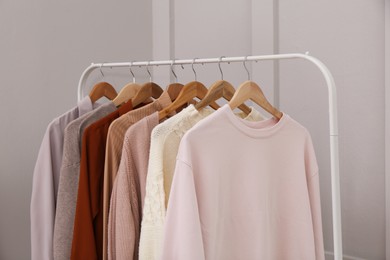 Photo of Rack with different stylish clothes near grey wall indoors