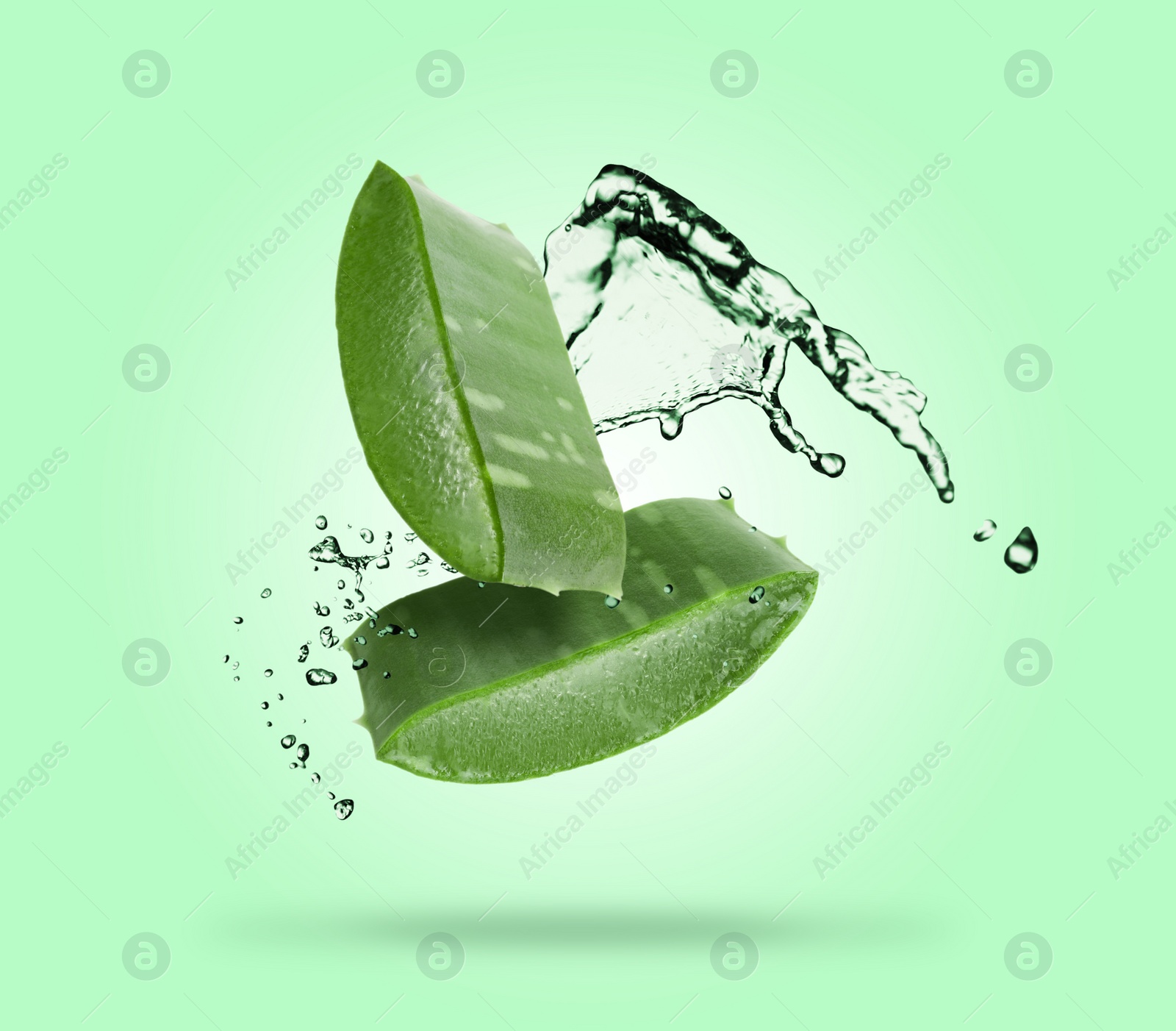 Image of Sliced aloe vera leaf and splashes of juice on aquamarine background