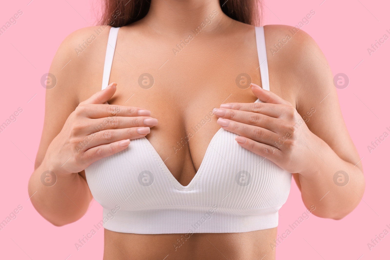 Photo of Woman with beautiful breast on pink background, closeup