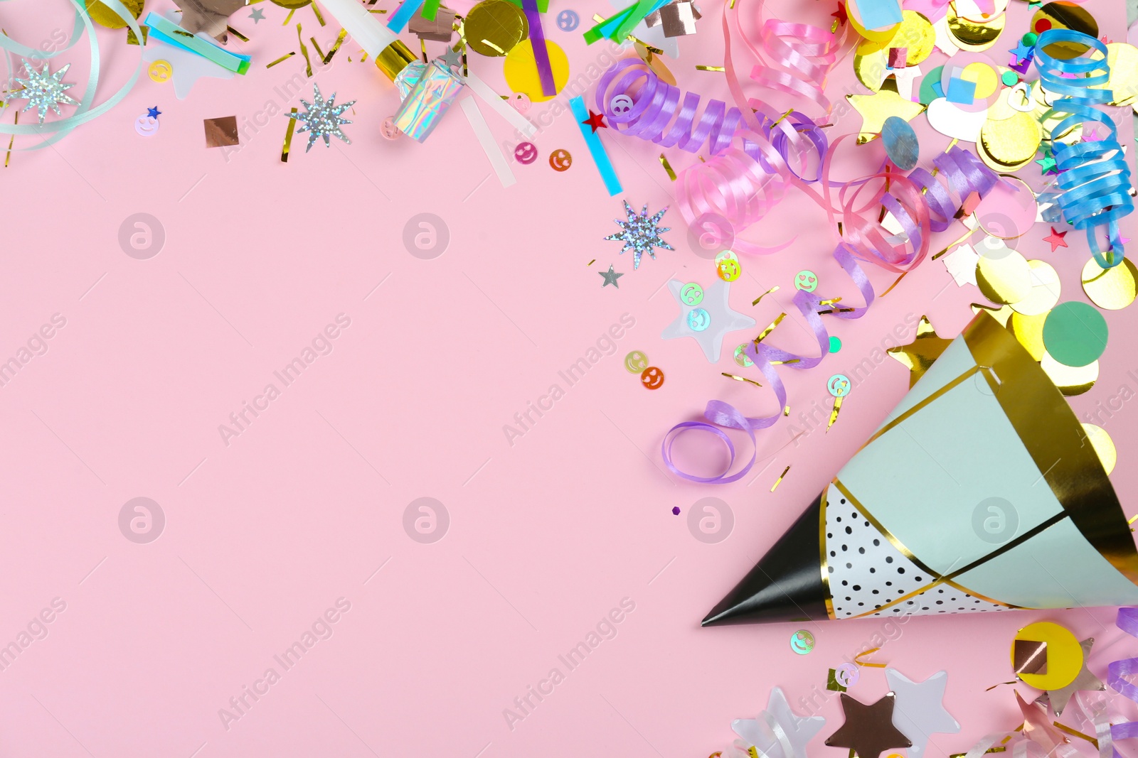 Photo of Colorful serpentine streamers, party hat, horn and confetti on pink background, flat lay. Space for text