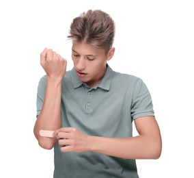 Photo of Handsome man putting sticking plaster onto elbow on white background