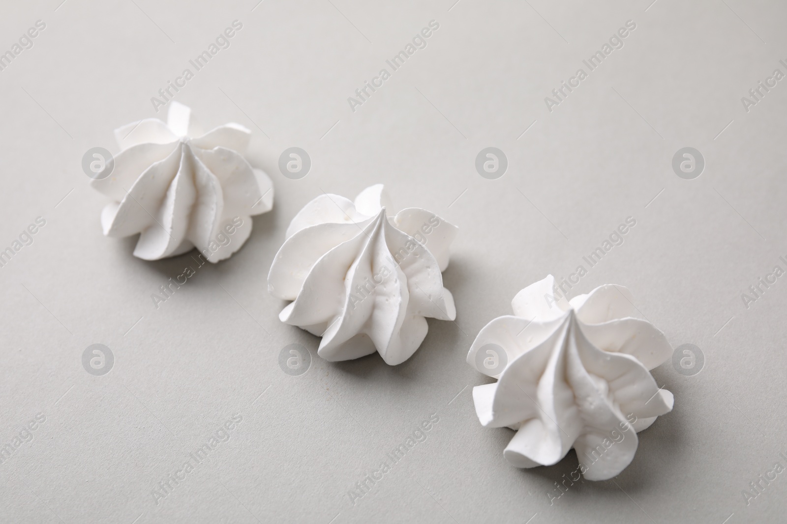 Photo of Tasty meringue cookies on light grey background