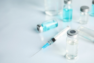 Photo of Vials and syringe on light table. Vaccination and immunization