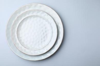Photo of Clean plates on light grey background, top view. Space for text
