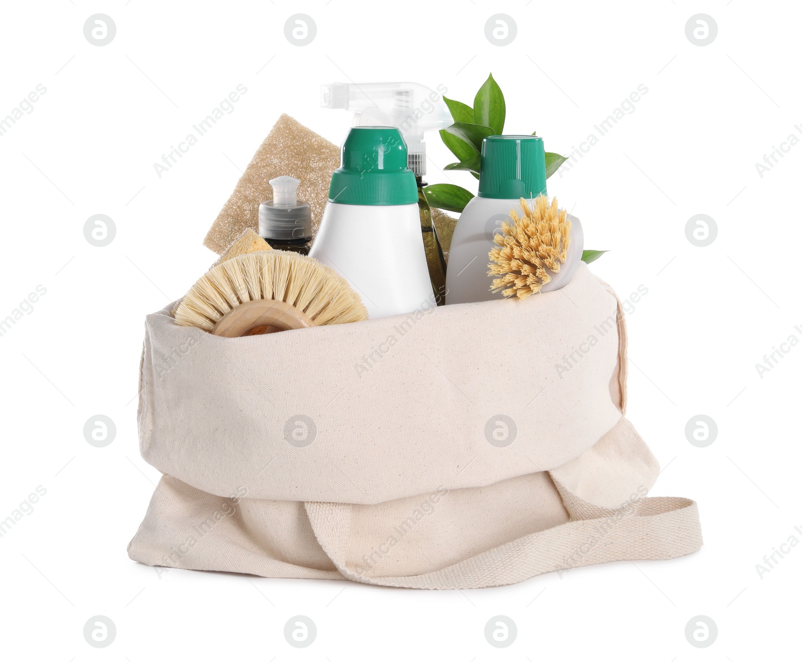 Photo of Bottles of cleaning product, brushes, sponges and green leaves in eco bag isolated on white