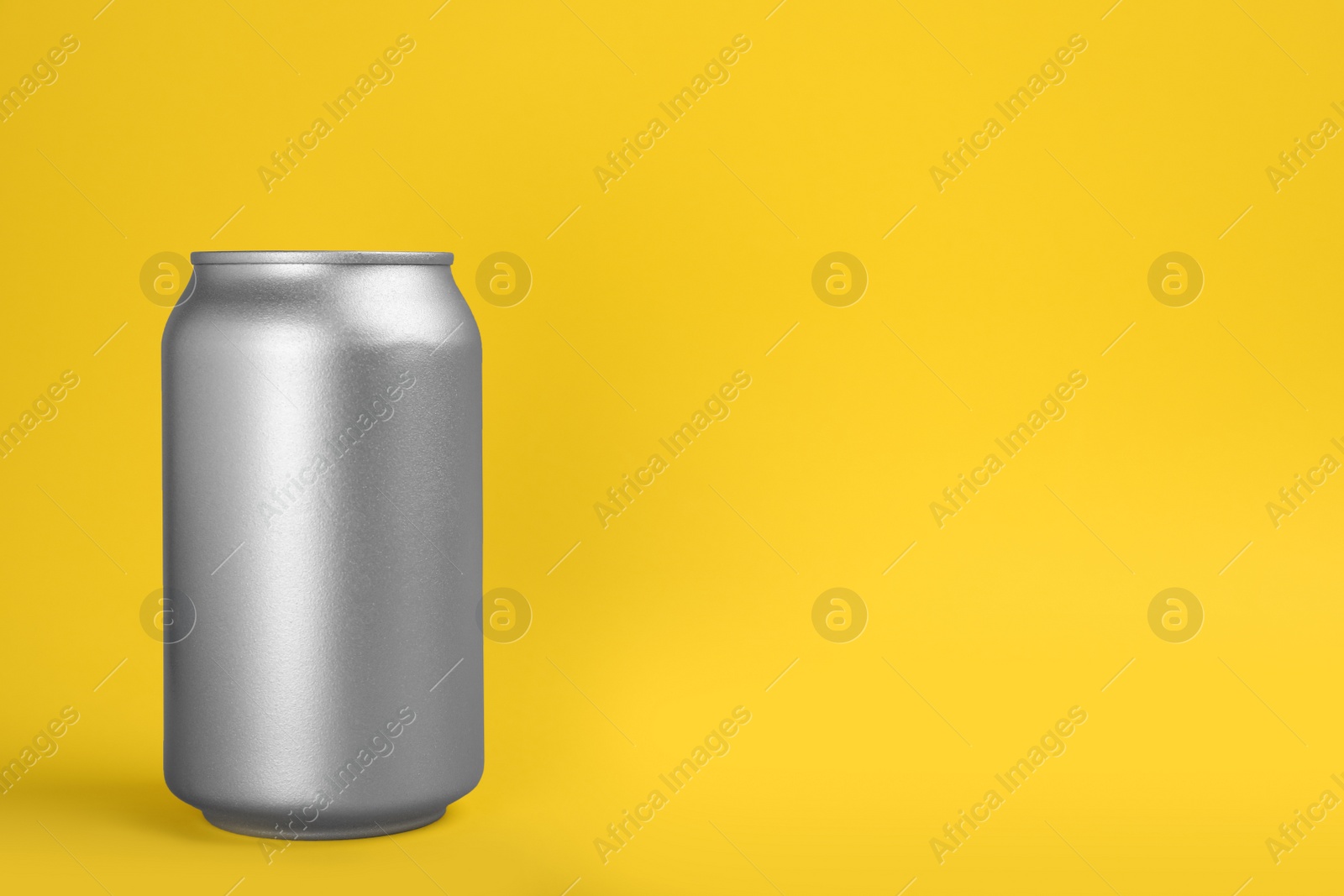 Photo of Can of energy drink on yellow background. Space for text
