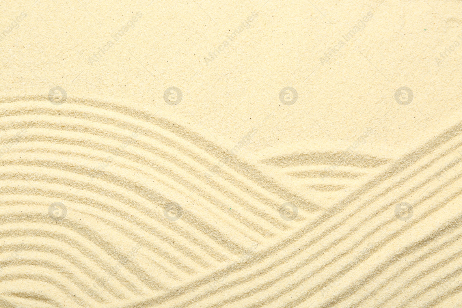 Photo of Zen rock garden. Wave pattern on beige sand, top view