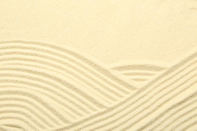 Photo of Zen rock garden. Wave pattern on beige sand, top view