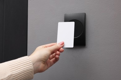 Photo of Woman opening magnetic door lock with key card, closeup. Home security