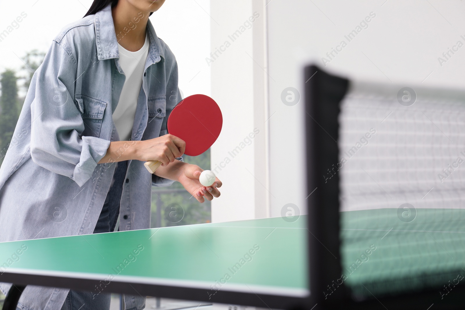 Photo of Woman playing ping pong indoors, closeup view. Space for text