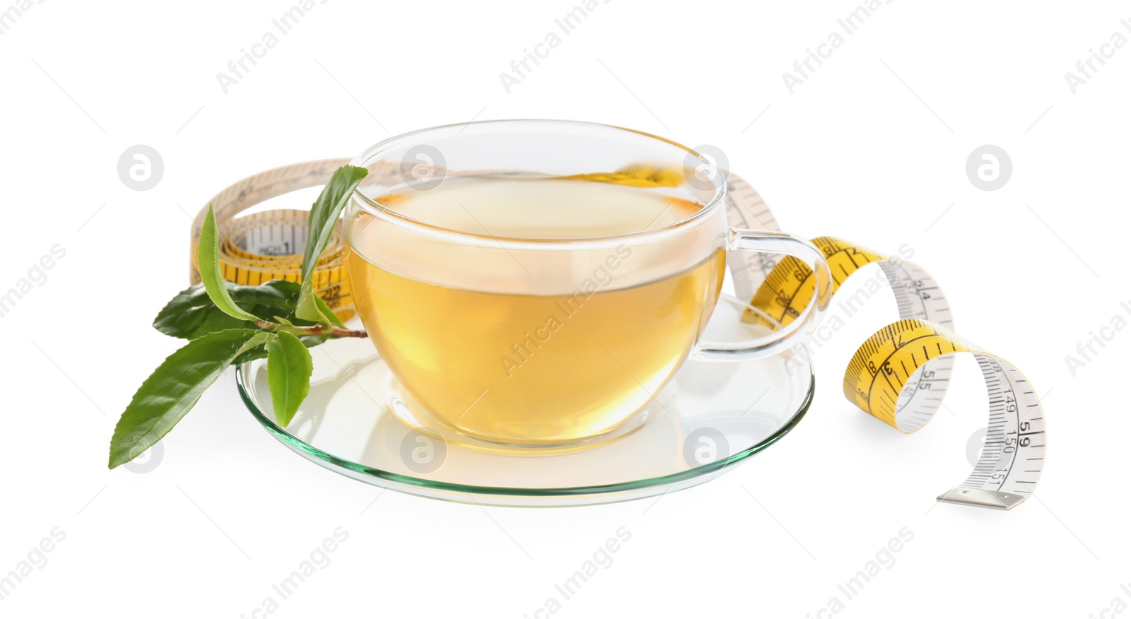 Photo of Glass cup of diet herbal tea, green leaves and measuring tape on white background