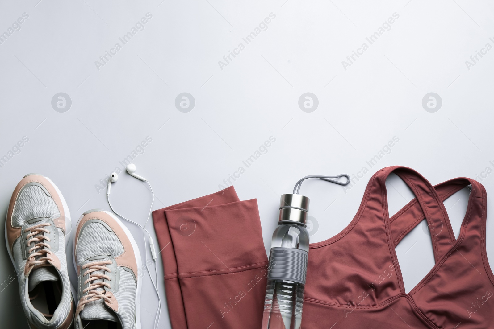 Photo of Flat lay composition with sportswear and equipment on light grey background, space for text. Gym workout