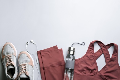 Photo of Flat lay composition with sportswear and equipment on light grey background, space for text. Gym workout