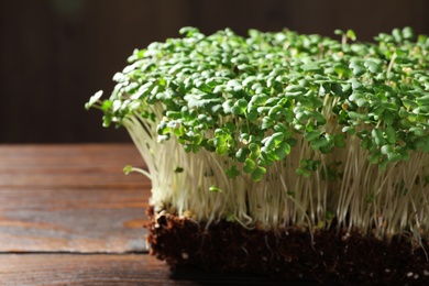 Photo of Fresh organic microgreen on wooden table, closeup