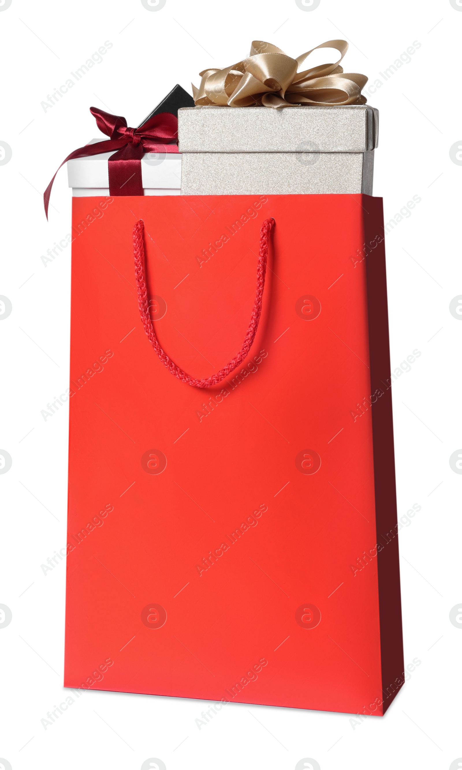 Photo of Red paper shopping bag full of gift boxes on white background
