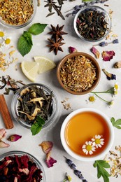 Flat lay composition with fresh brewed tea and dry leaves on light table