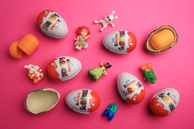 Sveti Vlas, Bulgaria - June 26, 2023: Kinder Surprise Eggs, plastic containers and toys on pink background, flat lay