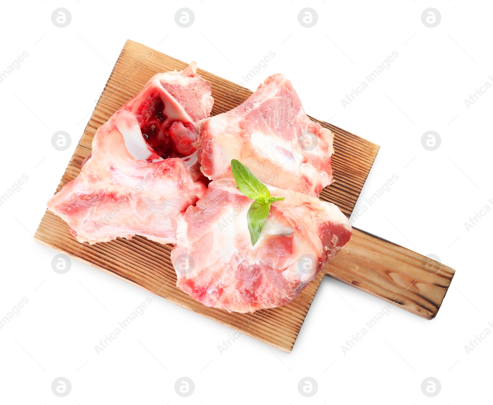 Photo of Wooden board with raw meaty bones and basil on white background, top view