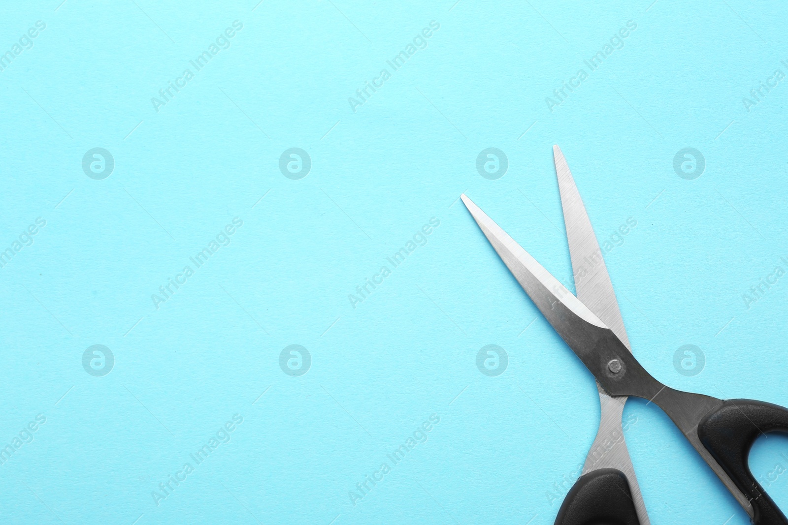 Photo of Pair of sharp scissors on color background, top view. Space for text