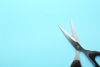 Pair of sharp scissors on color background, top view. Space for text