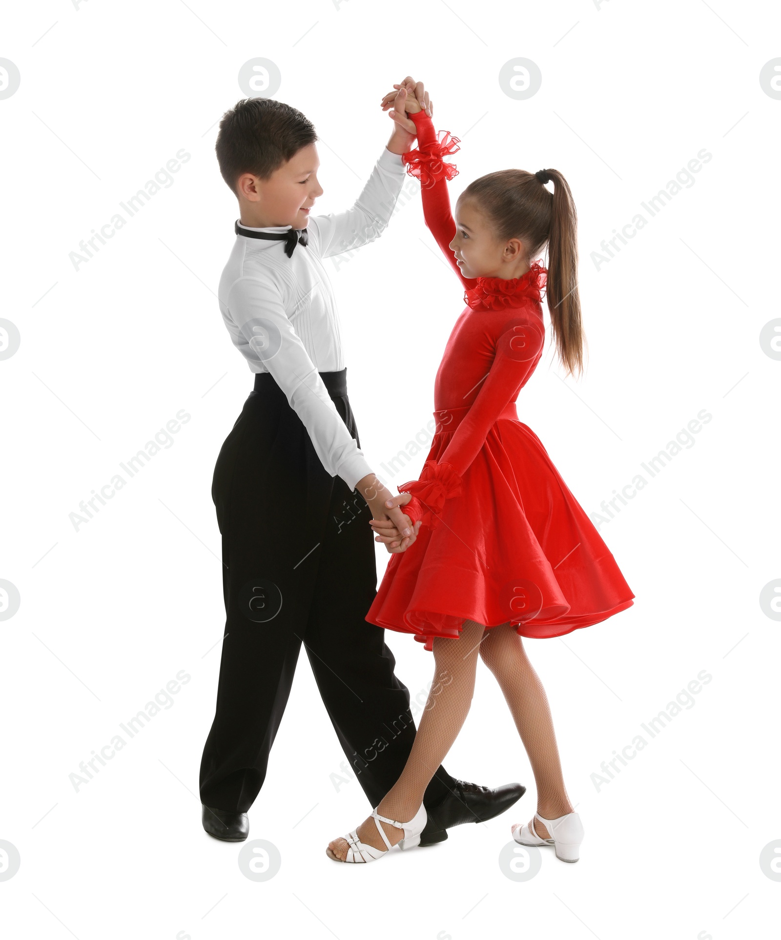 Photo of Beautifully dressed couple of kids dancing on white background
