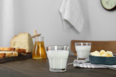Delicious milk, honey, butter and bread served for breakfast on wooden table