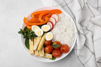 Delicious poke bowl with vegetables, eggs and tofu on light grey table, top view