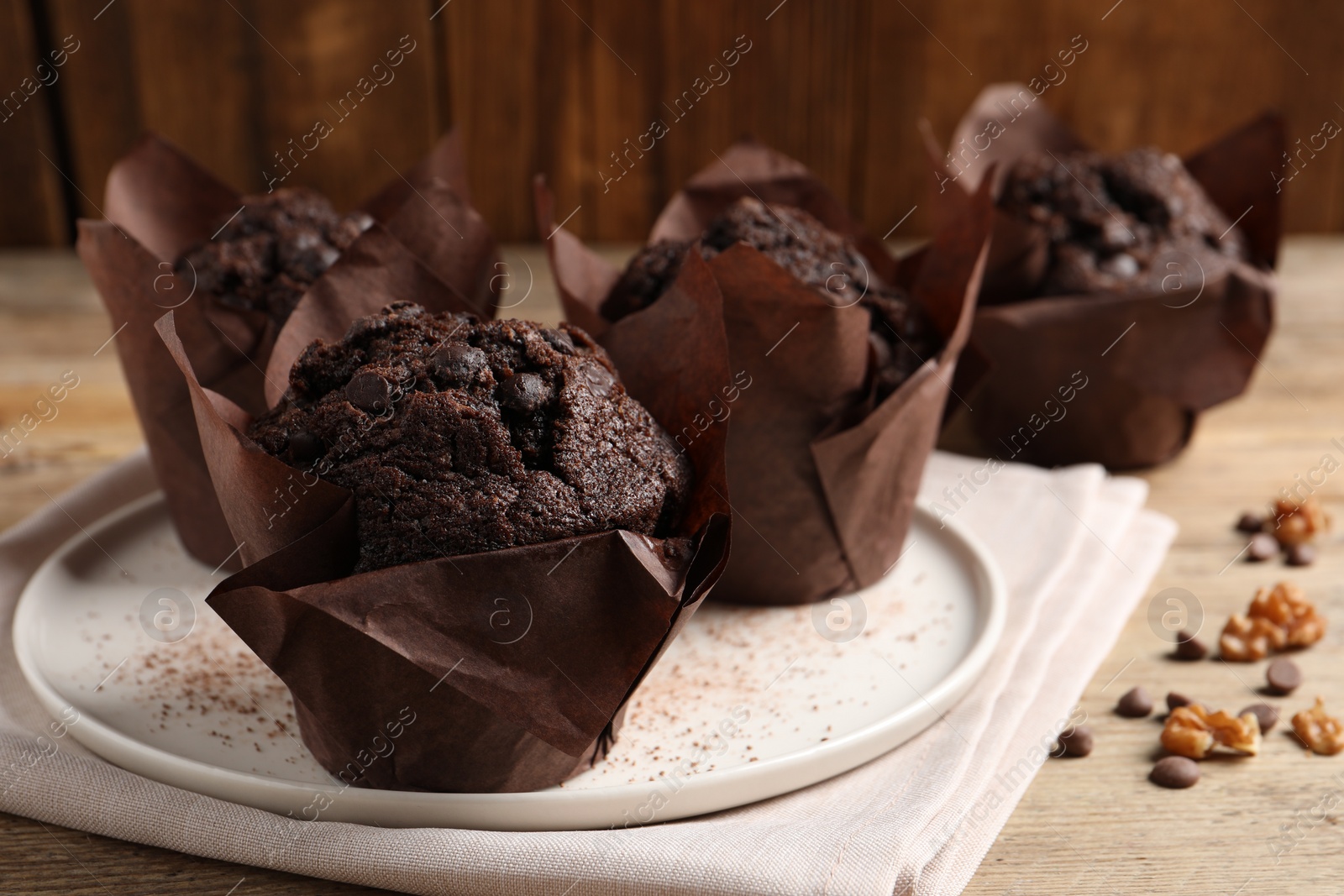 Photo of Tasty chocolate muffins on wooden table, closeup