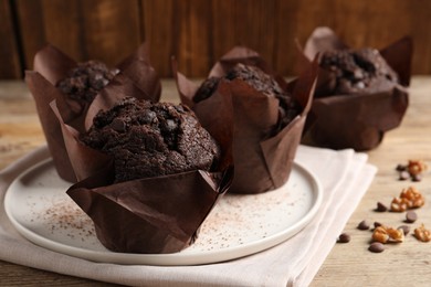 Photo of Tasty chocolate muffins on wooden table, closeup