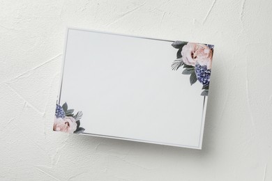 Photo of Blank invitation card on white table, top view