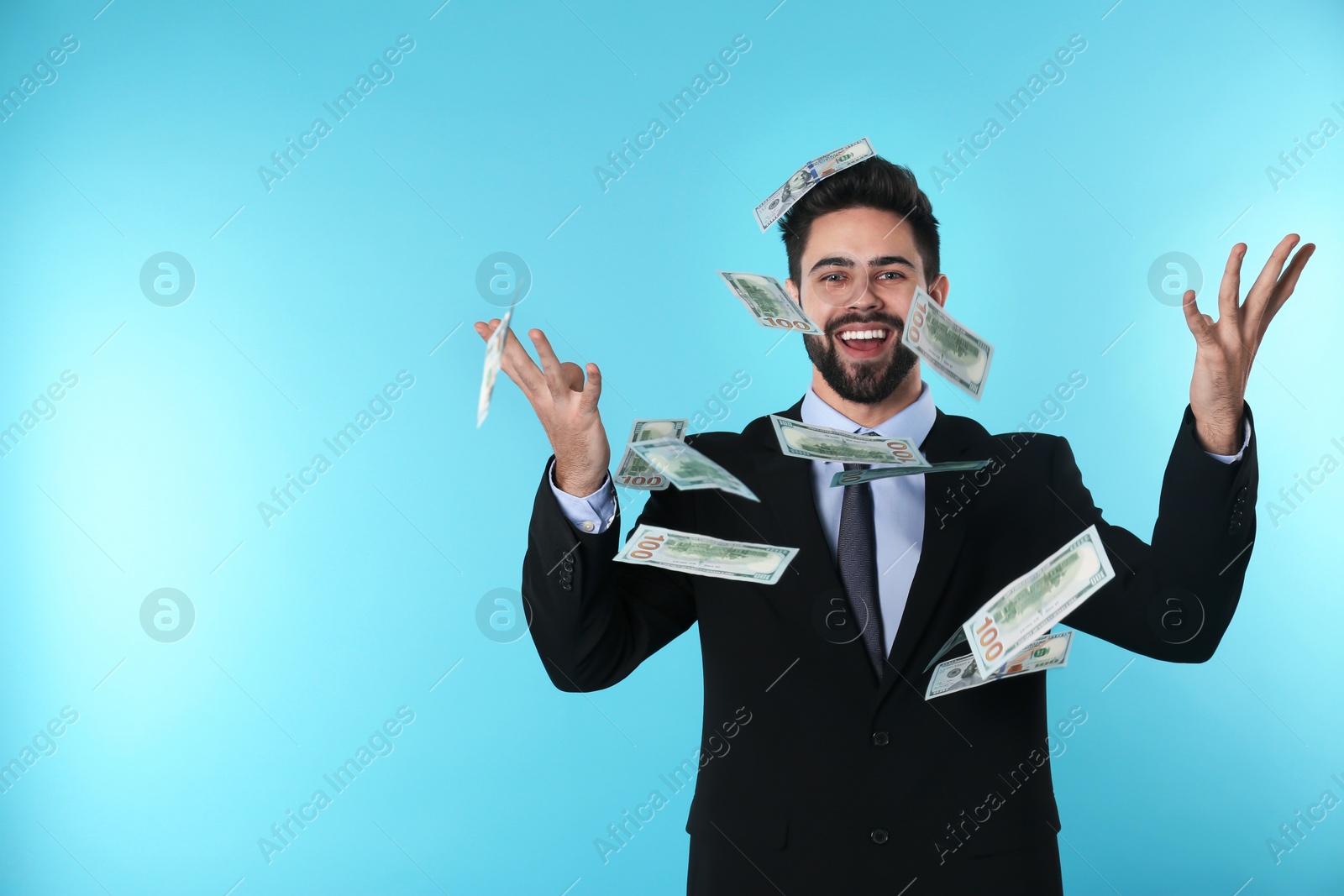 Photo of Happy young businessman throwing money on color background. Space for text