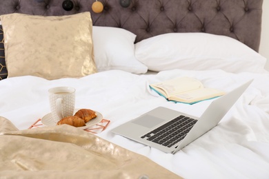 Laptop and breakfast on bed. Interior element