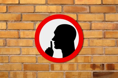 Image of Quiet Please sign with shush gesture image on orange brick wall