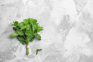 Bunch of fresh mint on grey marble table, top view. Space for text