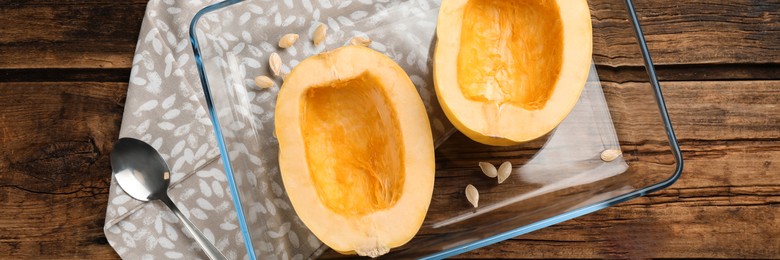 Image of Halves of fresh spaghetti squash in baking dish on wooden table, top view. Banner design