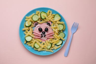 Creative serving for kids. Plate with cute bear made of tasty pasta, vegetables and sausage on beige background, flat lay