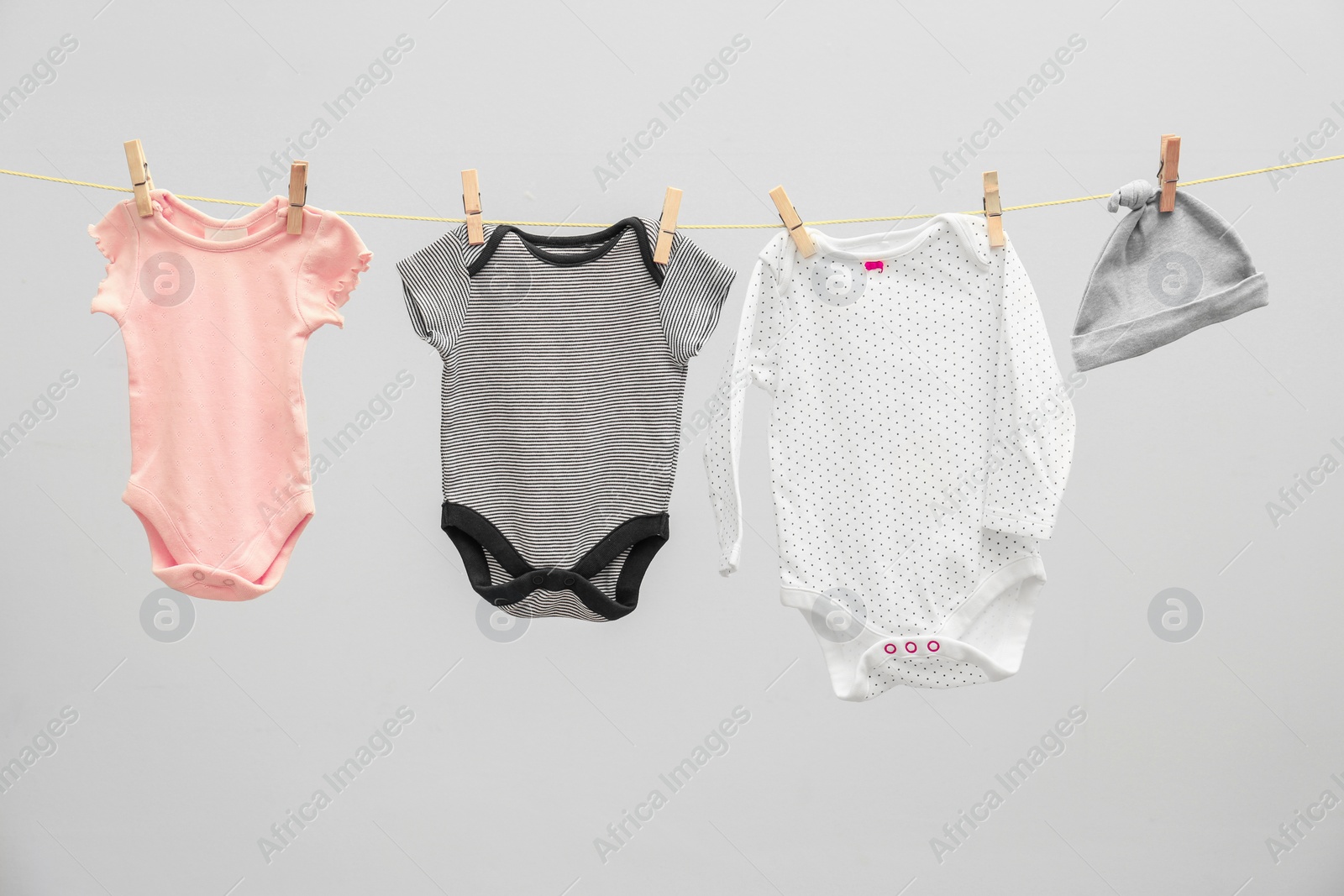 Photo of Children's clothes on laundry line against light background