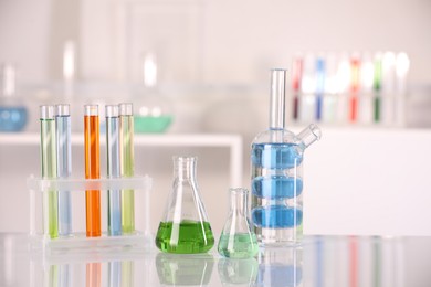 Photo of Laboratory analysis. Different glassware with liquids on white table indoors