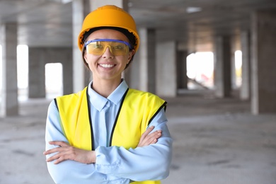 Photo of Professional engineer in safety equipment at construction site, space for text