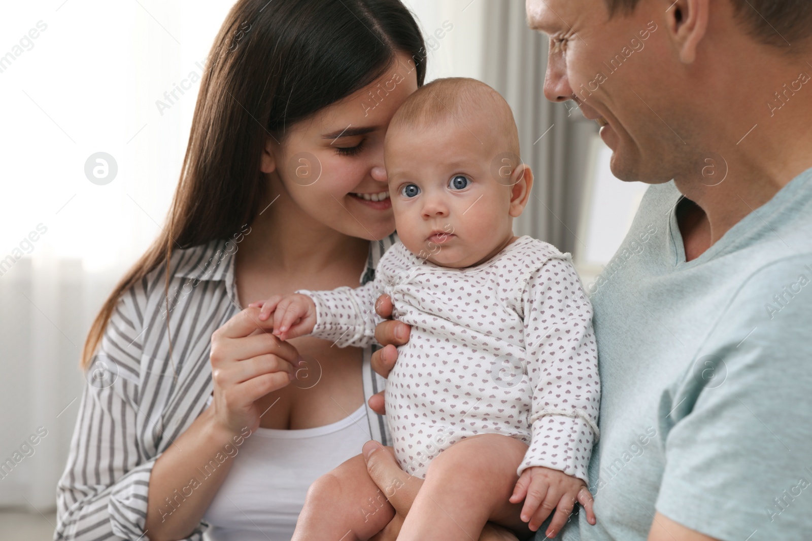 Photo of Happy family with their cute baby at home