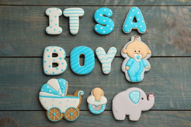 Photo of Baby shower party. Phrase It's A Boy made of cookies on light blue wooden background, flat lay