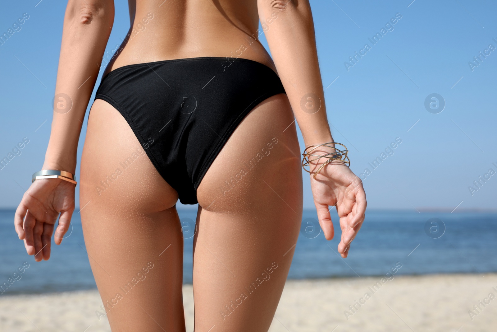 Photo of Young woman with beautiful body on beach, closeup