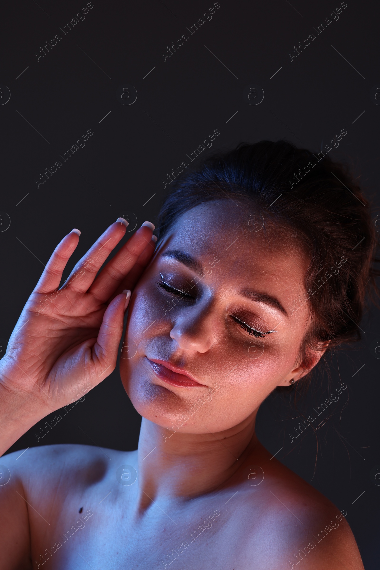 Photo of Portrait of beautiful young woman on dark background