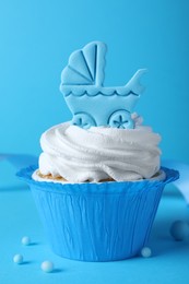 Photo of Beautifully decorated baby shower cupcake for boy with cream and topper on light blue background