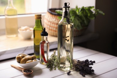 Different cooking oils and ingredients on white wooden table indoors