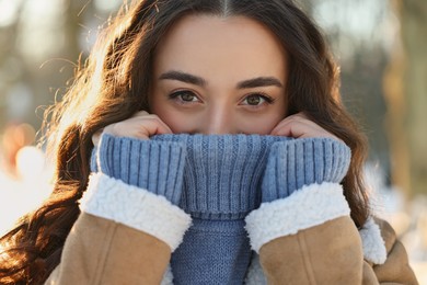 Photo of Portrait of young woman in sunny snowy park