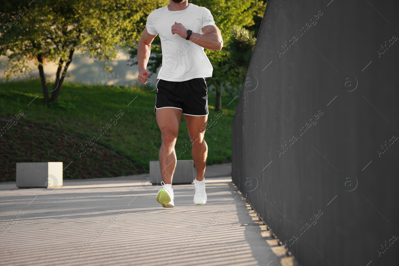 Photo of Man running outdoors on sunny day, closeup